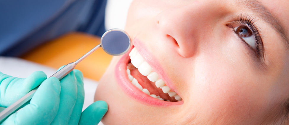 Examining teeth with dental mirror